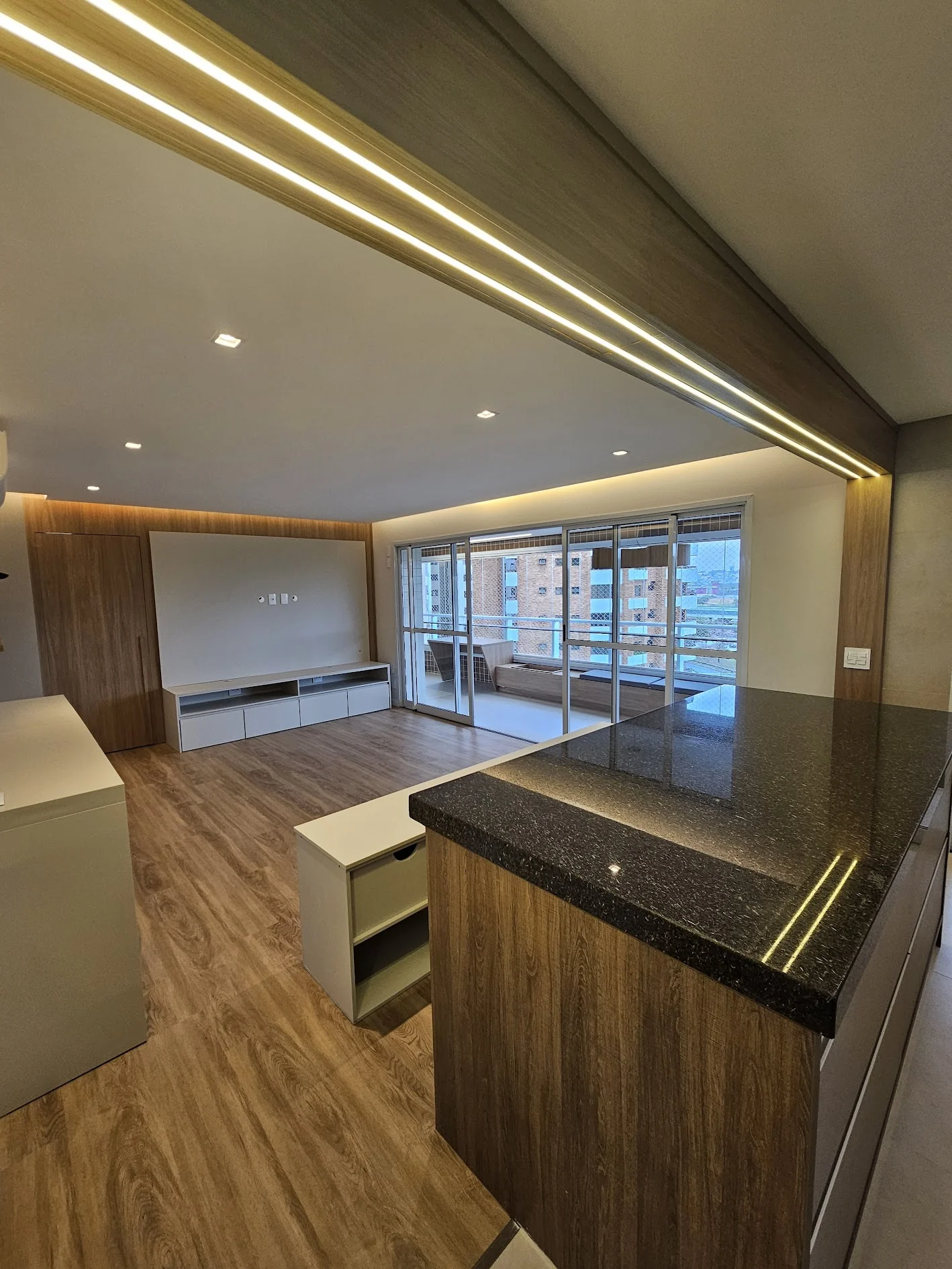 Apartamento reformado com cozinha integrada e acabamento em madeira